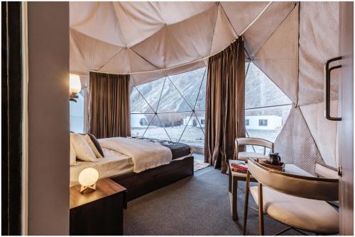 a bedroom with a canopy bed and a desk and a chair at The Crystal Resort in Hundar