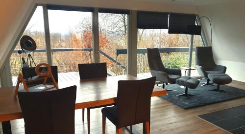 a dining room with a table and chairs and a large window at Bigge Huus Ferienhaus in Olpe