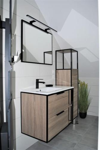 une salle de bain avec un lavabo et un miroir dans l'établissement Appartement 6 pers centre Gérardmer, à Gérardmer