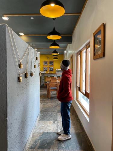 a person standing in a hallway looking out of a window at Prakriti-The Retreat in Gangotri