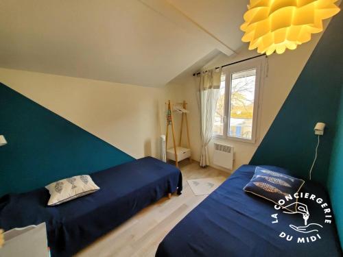 une chambre avec deux lits et une fenêtre dans l'établissement Lo Cabanot, à Port-la-Nouvelle