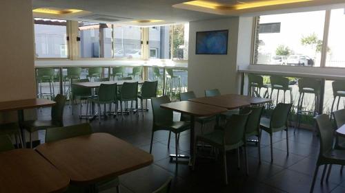 - une salle à manger avec des tables, des chaises et des fenêtres dans l'établissement SUN1 PRETORIA, à Pretoria