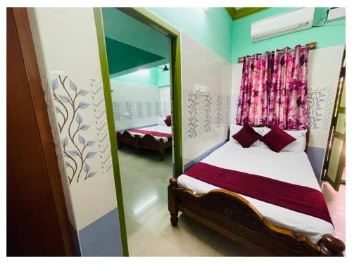 ein Schlafzimmer mit einem Spiegel und einem Bett in einem Zimmer in der Unterkunft Udhayam Residency in Kāraikāl