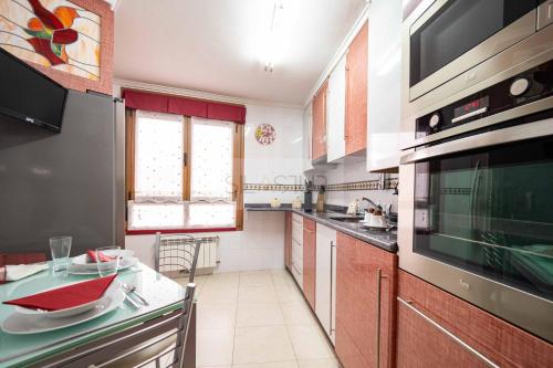 cocina con fregadero y fogones horno superior en Casa Nerai Apartamento, en Gijón