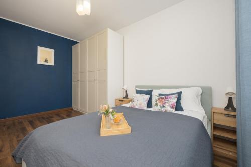 a bedroom with a bed with a wooden tray on it at Trzy Żagle - City View Apartments with Balcony by Renters in Gdańsk