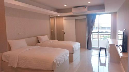 a hotel room with two beds and a balcony at PKK hotel Residence in Bang Phli