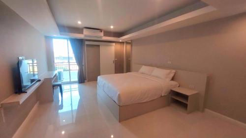 a bedroom with a bed and a television in it at PKK hotel Residence in Bang Phli