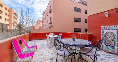 a patio with tables and chairs on a balcony at AiM HOUSE in Marrakech