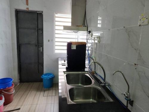 a kitchen with a stainless steel sink and a window at IPOH BOTANI bauhaus 17pax/4BR/mahjong/tv box in Ipoh