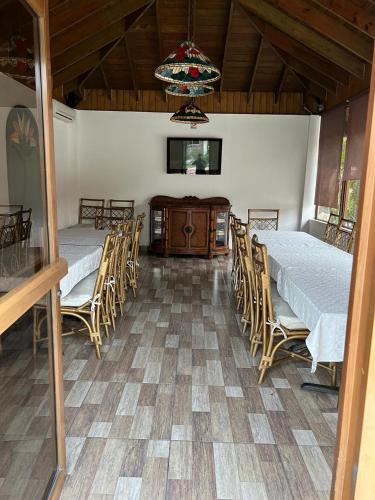 a dining room with two tables and chairs and a chandelier at Hotel Tropicana Santo Domingo in La Viva