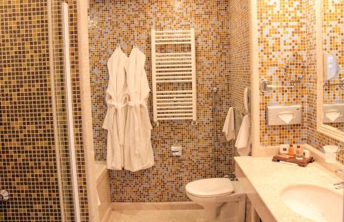 a bathroom with a shower with a toilet and a sink at Grand Hotel Pomorie - Medical spa in Pomorie