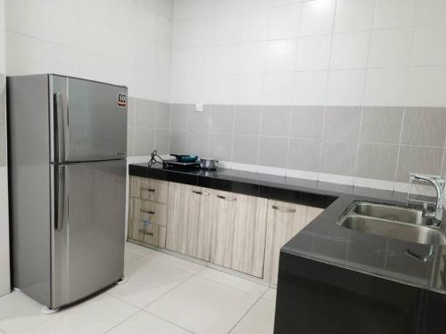 a kitchen with a stainless steel refrigerator and a sink at IPOH BOTANI bauhaus 17pax/4BR/mahjong/tv box in Ipoh
