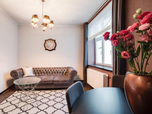 a living room with a couch and a table with roses at Too-Good Premium Apartments in Krakow