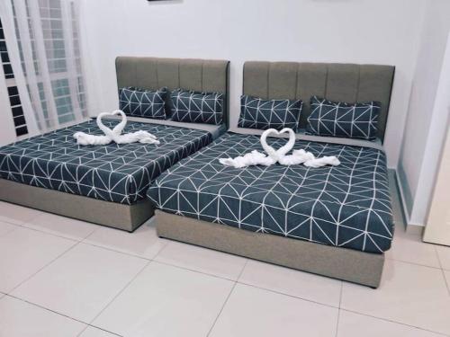 two beds with white rings on them in a room at IPOH BOTANI bauhaus 17pax/4BR/mahjong/tv box in Ipoh