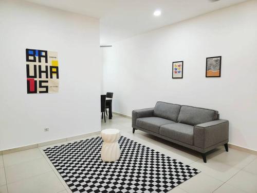 a living room with a couch and a rug at IPOH BOTANI bauhaus 17pax/4BR/mahjong/tv box in Ipoh