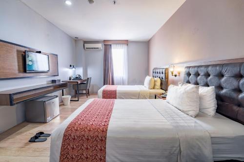 Postel nebo postele na pokoji v ubytování Grand Kangen Hotel Urip Sumoharjo
