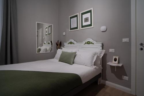 ジェノヴァにあるRooms Genova dei Rolliのベッドルーム1室(白いシーツと枕のベッド1台付)