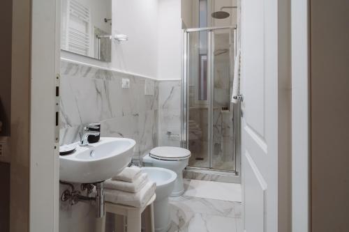 een badkamer met een wastafel, een toilet en een douche bij Rooms Genova dei Rolli in Genua