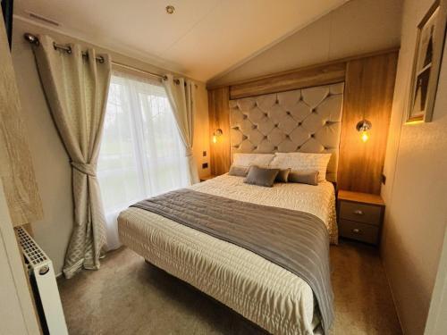 a bedroom with a large bed and a window at White Swan Lodge in Allerthorpe