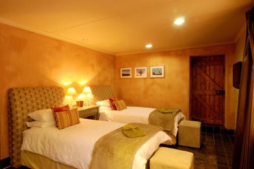 a hotel room with two beds and a door at Sherewood Lodge in Pretoria