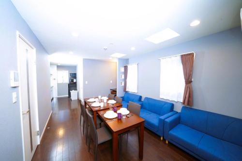 a living room with a blue couch and a table at 浅草ザ アパートメント Asakusa The Apartment in Tokyo