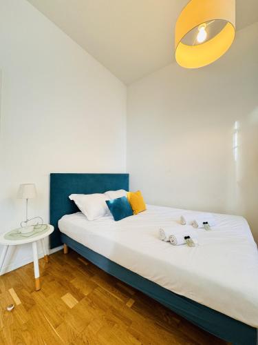 - une chambre avec un lit blanc et une tête de lit bleue dans l'établissement Studio chaleureux proche croisette Mimont29, à Cannes