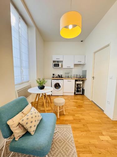 un salon avec une chaise bleue et une table dans l'établissement Studio chaleureux proche croisette Mimont29, à Cannes