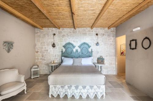 1 dormitorio con cama y pared de piedra en RoccaSeta en Scicli
