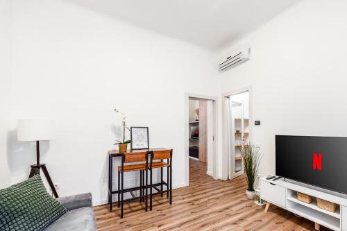 Una sala de estar con un televisor y una mesa. en Charming Sempione - Milano MiCo - Arco della Pace, en Milán