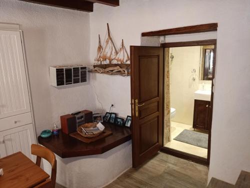 a bathroom with a door and a table with a microwave at Kissamitakis Guesthouse in Monemvasia