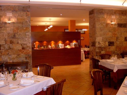 ボカイレントにあるL'Agora Hotelの白いテーブルと椅子、キッチン付きのレストラン