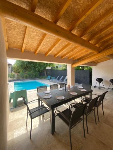 une salle à manger avec une table et des chaises et une piscine dans l'établissement Ma Location en Provence, à Cabrières-dʼAigues