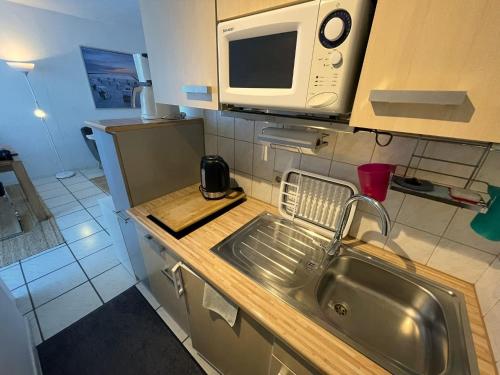 a kitchen with a sink and a microwave at Seesternchen in Heiligenhafen