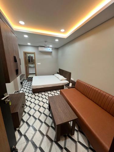 een hotelkamer met een bed en een bank bij TIC ROOMS in Siliguri