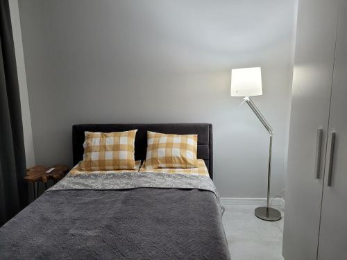 um quarto com uma cama com duas almofadas e um candeeiro em Apartament Walendów Park em Walendów