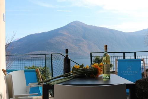 a table with two bottles of wine and flowers on it at Lakeview Cannobio Camping & Resort in Cannobio