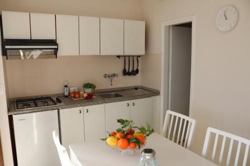 a kitchen with a table with a bowl of fruit on it at Lakeview Cannobio Camping & Resort in Cannobio