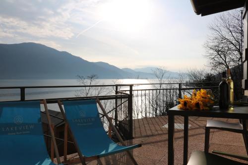 a table and chairs on a balcony with a view of the water at Lakeview Cannobio Camping & Resort in Cannobio