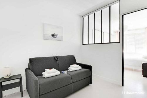ein Wohnzimmer mit einem Sofa mit zwei Handtüchern darauf in der Unterkunft Amazing apartment 3BR Convention in Paris