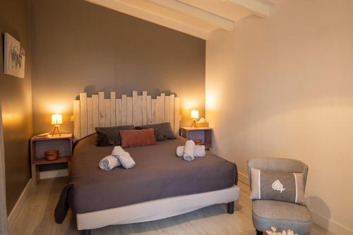 a bedroom with a large bed and a chair at Les granges du chiron in La Garnache