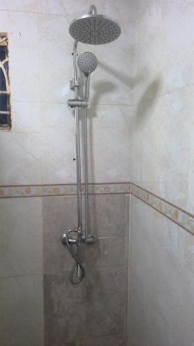 a shower in a bathroom with a shower head at MAYRAH Inn - Your comfortable home from home in Freetown Sierra Leone in Goderich