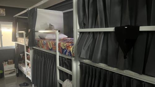 a room with a bunk bed and a bed with curtains at W District hostel in Bangkok