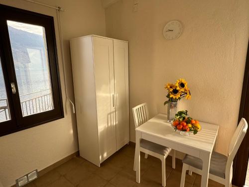 a small white table with a vase of flowers on it at Lakeview Cannobio Camping & Resort in Cannobio