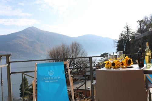 a table with wine glasses and a sign on a balcony at Lakeview Cannobio Camping & Resort in Cannobio