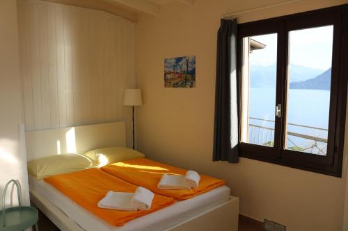 a bedroom with a bed with two pillows and a window at Lakeview Cannobio Camping & Resort in Cannobio