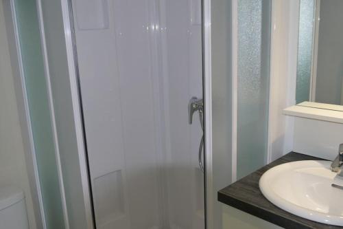 Un baño con ducha de cristal y lavabo. en Appart face mer, magnifique vue mer : Ile aux Moines, en La Bernerie-en-Retz