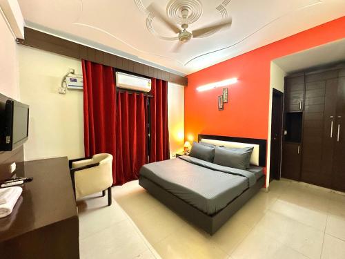 a bedroom with a bed and a red wall at entire house 17 rooms best for marriage/gatherings functions in Gurgaon