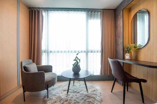 a living room with a table and chairs and a window at The house of us in Manila