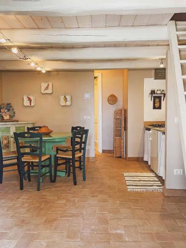 a dining room with a green table and chairs at Pietra Pizzuta Country House in Torre deʼ Passeri