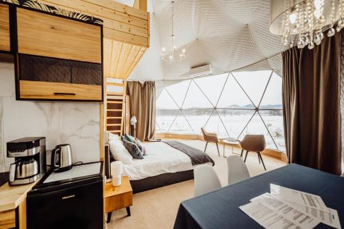 a hotel room with a bed and a large window at Karkonoski Glamping in Łomnica